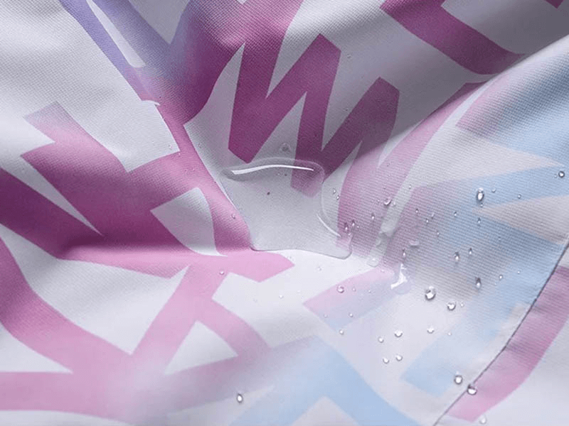 Close-up of waterproof letter print on stylish female ski jacket - SF1787, showing water droplets on durable polyester fabric.